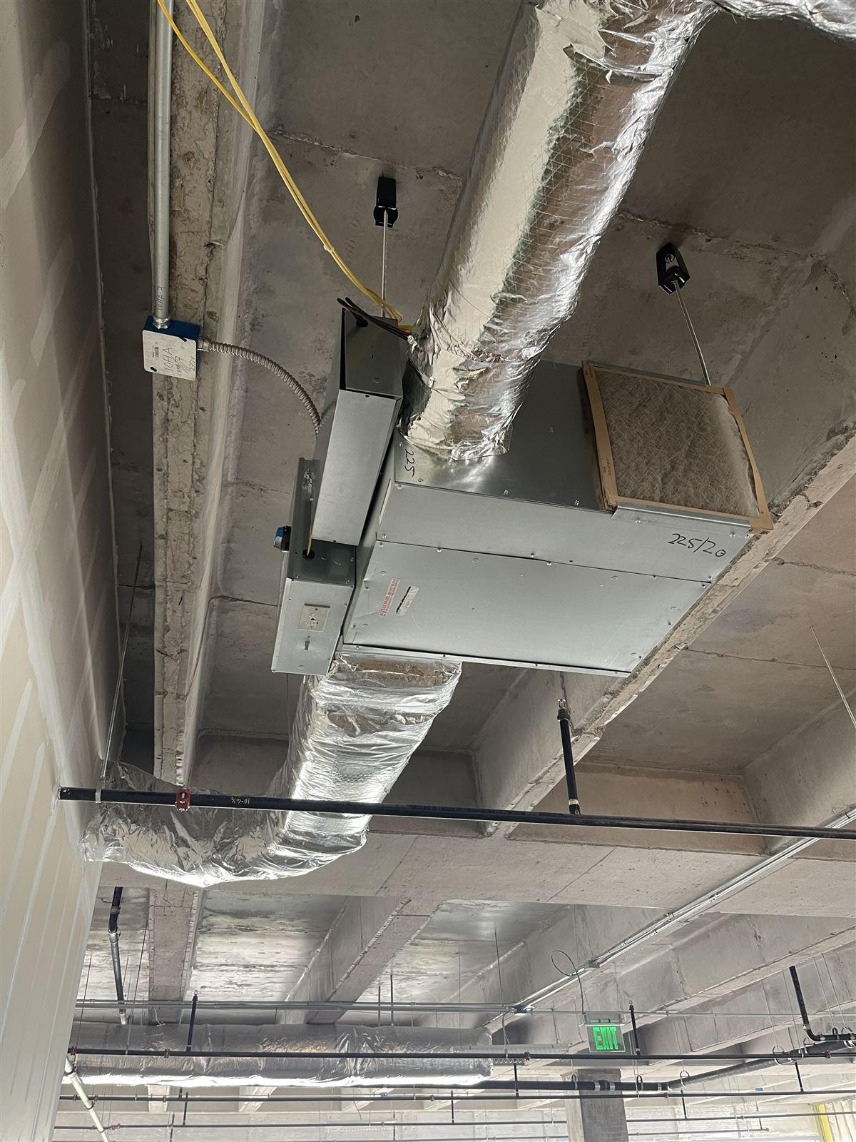 Suspended air handler with filter and insulated duct runs in a concrete commercial structure