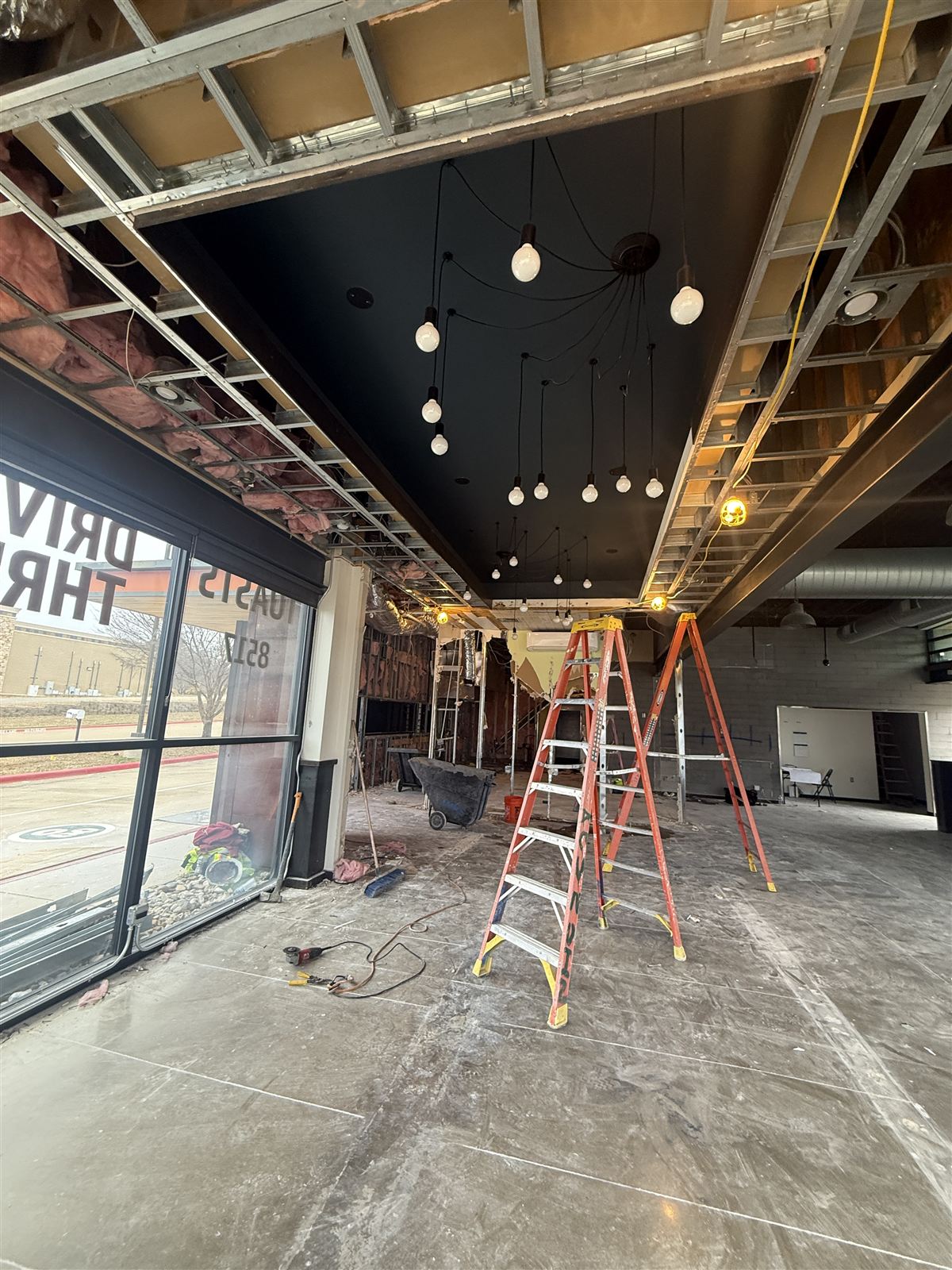 TruGrocer branch interior during buildout with ceiling framing and the drive-thru area in progress
