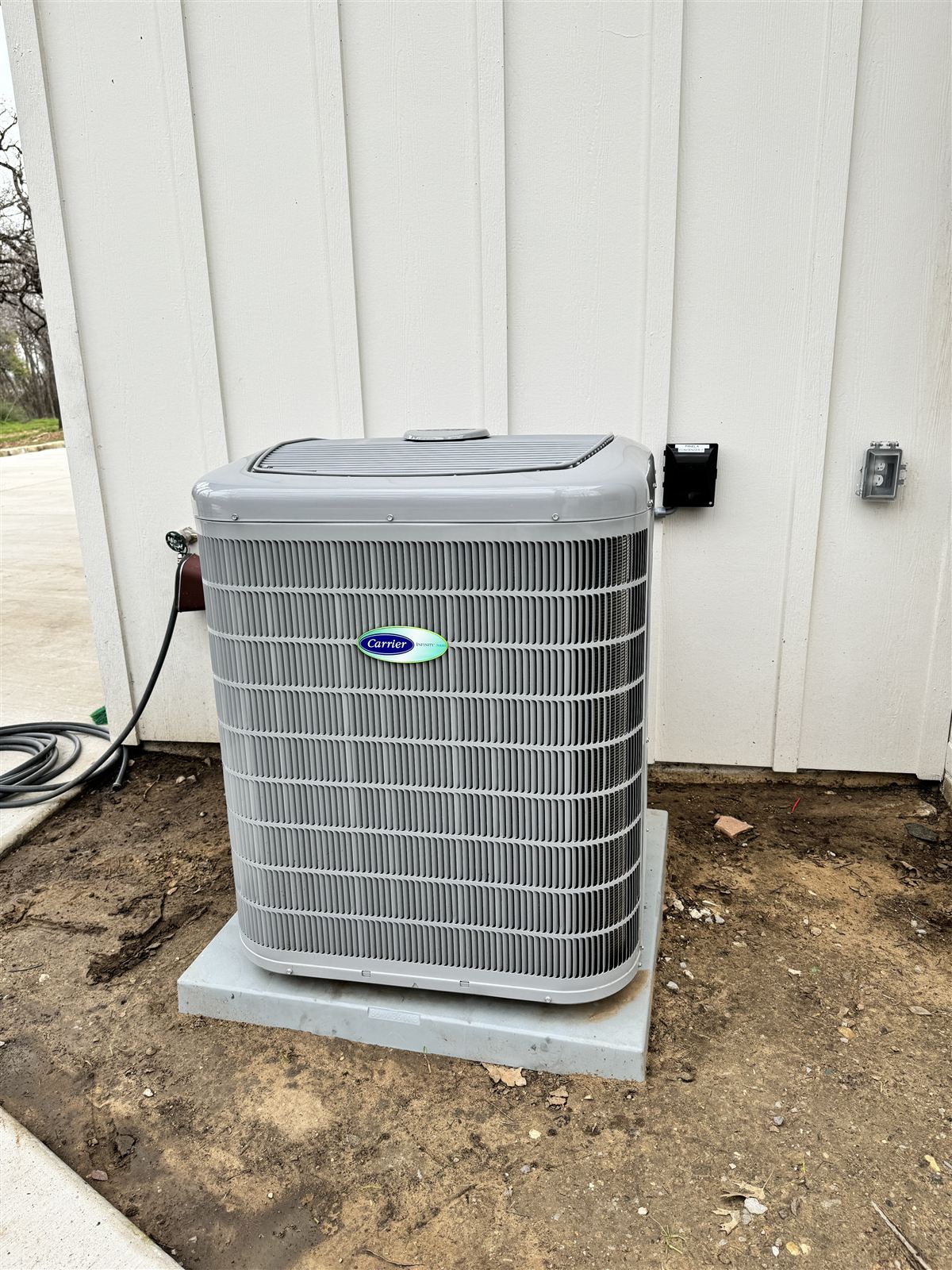 Carrier Infinity series condenser cleanly installed on a pad at a DFW residence