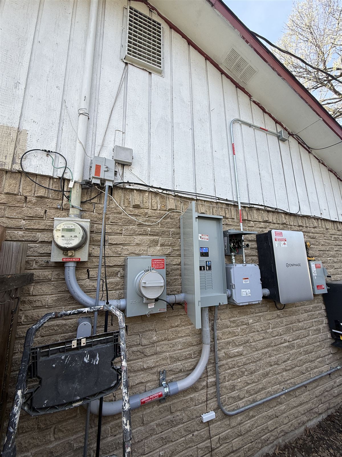Complete Enphase balance-of-system installation — IQ System Controller, load center, PV disconnect, and labeled conduit on a DFW home